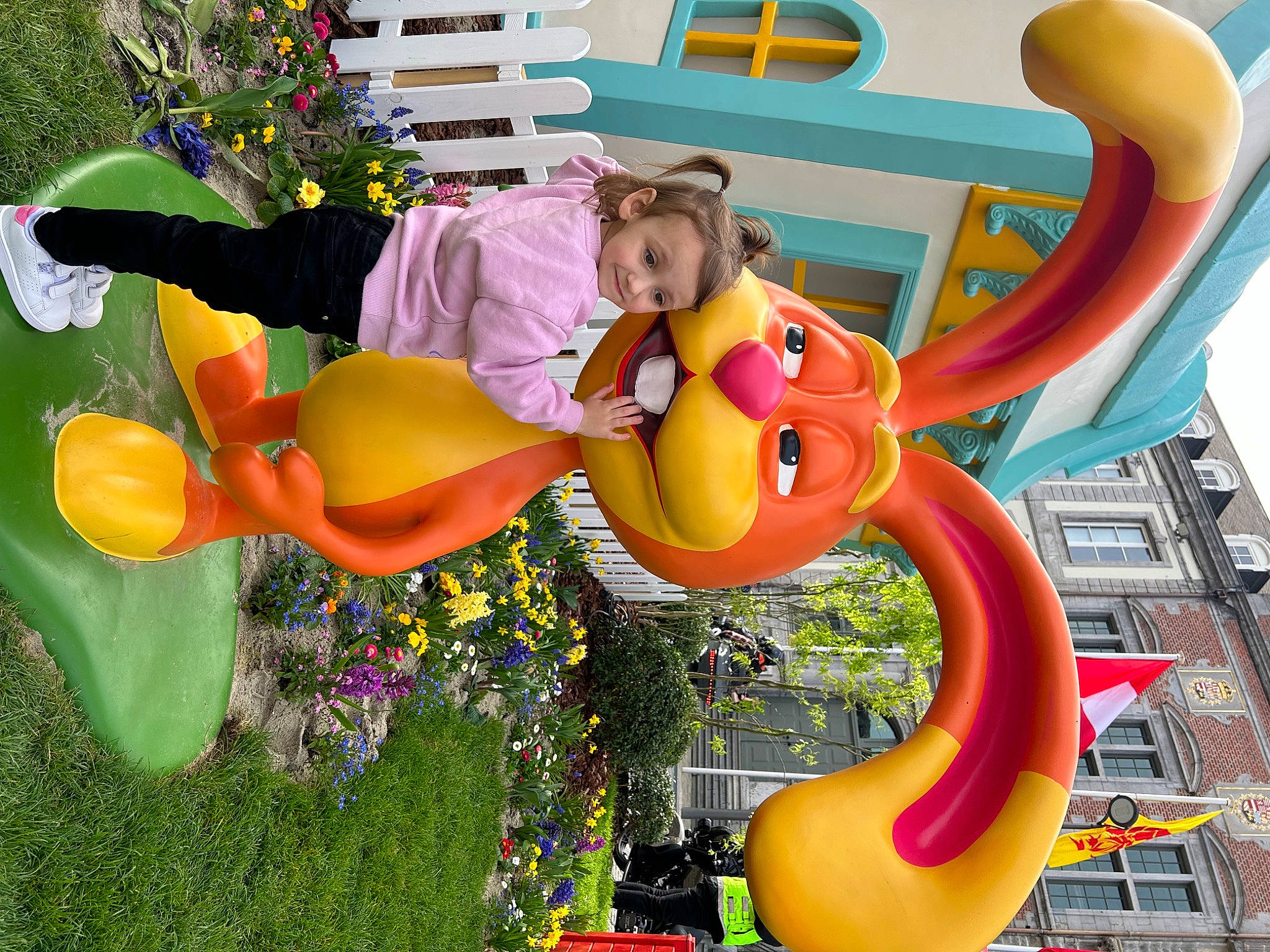 Leona a rejoint le concours — aidez-le/la à gagner de superbes lots ! amusement_park, animated_cartoon, animation, art, building, city, event, fictional_character, flower, fun, happy, lawn_ornament, leisure, nonbuilding_structure, party_supply, person, plant, recreation, tree, world