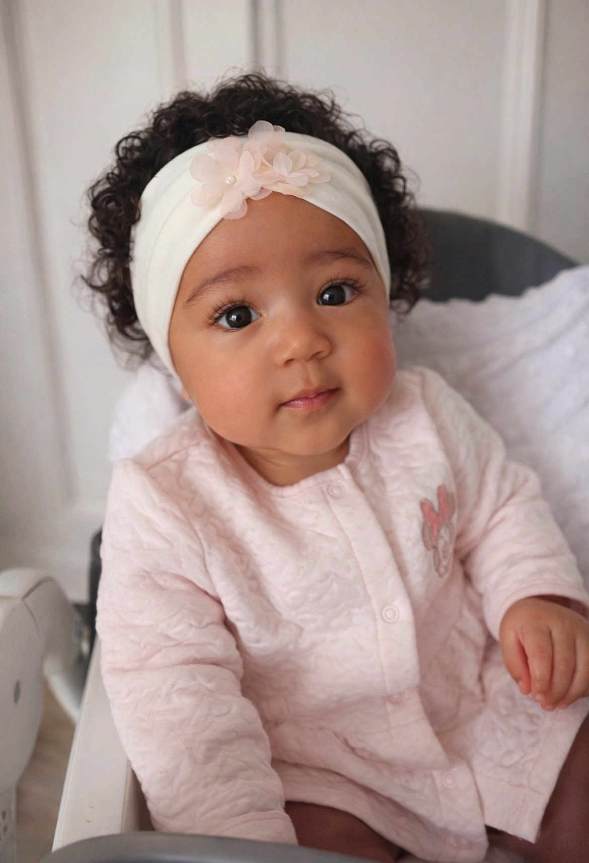 Maria a rejoint le concours — aidez-le/la à gagner de superbes lots ! baby, infant, toddler, headband, curly_hair, big_eyes, pink_outfit, onesie, highchair, portrait, indoor, adorable, sitting, closeup, face, eyelashes, nursery, hand, soft_texture, flower
