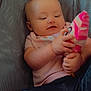 baby, child, infant, person, toy, sock, clothing, pink_shirt, blue_pants, mesh_chair, curious, cute, hands, face, smile, indoor, cozy, seated, playful, closeup