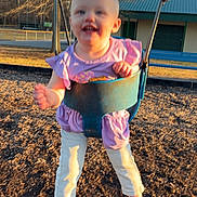 Ella Mae is registered to the contest to win money with this photo: child, toddler, swing, playground, outdoor, barefoot, purple_clothing, trees, sunlight, smiling, fun, play, metal_chains, woodchips, park, daylight, blurry_face, happy, person, recreation