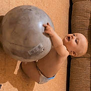 Ella Mae joined the competition — help win amazing prizes! baby, diaper, exercise_ball, floor, couch, indoor, child, curious, playful, tiled_floor, infant, grip, round_object, home, cute, sitting, light, shadow, skin, expression