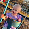 toddler, child, swing, playground, purple_dress, sunlight, outdoor, smiling, happy, person, grass, trees, park, casual_clothing, daytime, recreation, fun, young_child, play, nature