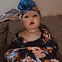 baby, blue, child, clothing, colorful, couch, cute, expression, face, flower, hands, headband, indoors, infant, pacifier, person, sitting, skin, toy, young