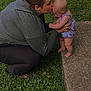 baby, adult, grass, concrete, outdoor, kiss, affection, love, holding, child, nature, crouching, greenery, person, tenderness, bonding, cute, support, summer, casual_clothing