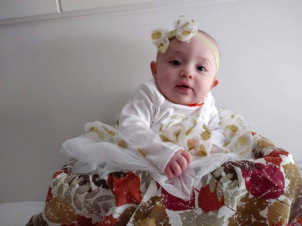 Raelynn joined the competition — help win amazing prizes! baby, baby_toddler_clothing, bridal_accessory, cheek, child, comfort, dress, embellishment, fashion_accessory, flash_photography, hair_accessory, happy, head, headband, headpiece, linens, peach, person, sitting, sleeve