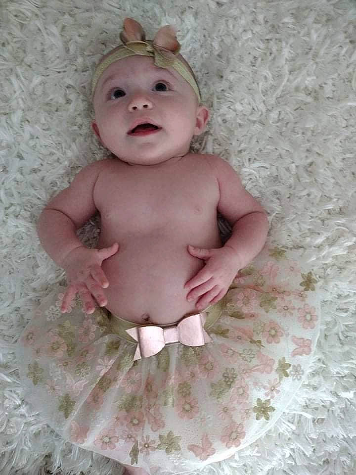 Raelynn is registered to the contest to win money with this photo: baby, baby_products, baby_toddler_clothing, baby_toys, cheek, child, costume_accessory, eye, fashion_accessory, happy, head, headgear, headwear, linens, lip, pattern, person, pink, sitting, sleeve