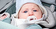 Oscar is registered to the contest to win money with this photo: baby, blanket, bonnet, clothing, face, happy, hat, head, person, yawning