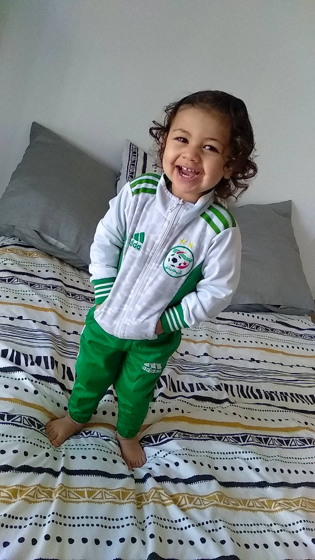 Yanis a rejoint le concours — aidez-le/la à gagner de superbes lots ! arm, baby_toddler_clothing, comfort, face, flash_photography, floor, flooring, happy, head, joy, linens, pattern, person, pillow, sitting, sleeve, smile, sportswear, t_shirt, thigh