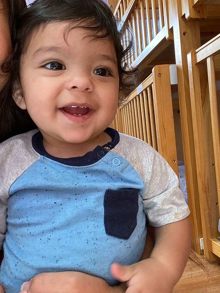 Jose is registered to the contest to win money with this photo: arm, baby_toddler_clothing, cheek, chin, eye, face, hairstyle, happy, head, human_body, lip, mouth, neck, nose, organ, person, product, shoulder, skin, sleeve