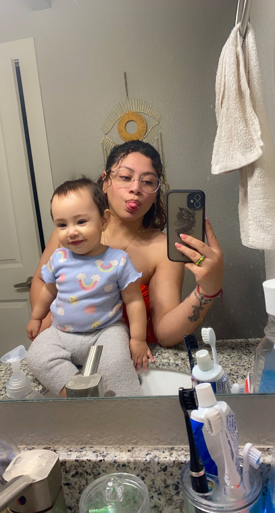 Leila is registered to the contest to win money with this photo: abdomen, baby, child, couch, event, eyewear, face, finger, fun, hand, happy, head, joy, living_room, mirror, person, room, shorts, sitting, t_shirt