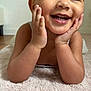 toddler, child, smiling, hands_on_face, indoor, pink_rug, soft_texture, happy, cute, portrait, skin, face, eyes, teeth, baby, person, lying_down, expression, closeup, head