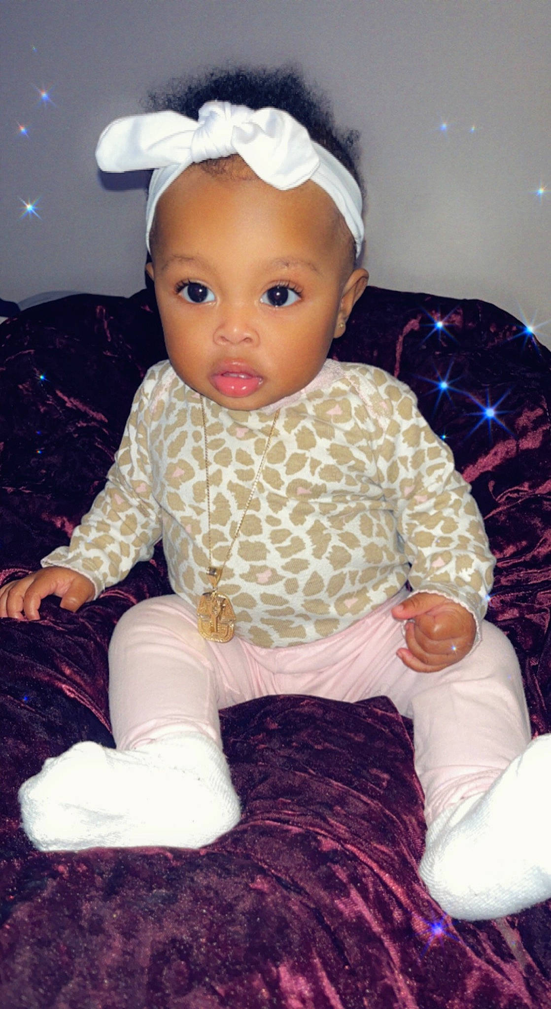 Shanel is registered to the contest to win money with this photo: arm, baby, baby_toddler_clothing, cheek, child, doll, finger, head, human_body, magenta, pattern, person, pink, purple, skin, sleeve, sock, toddler, toy, white