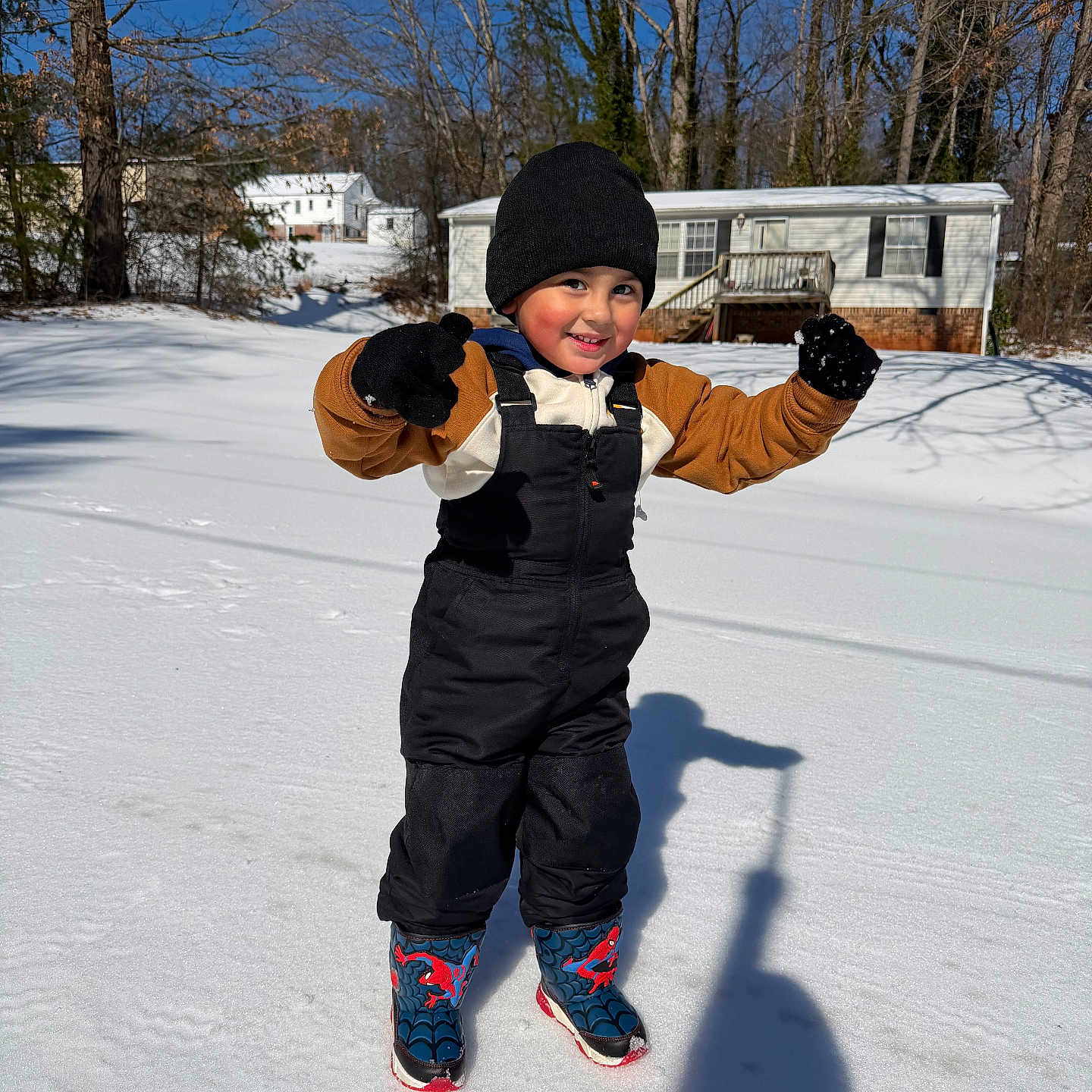 Iker joined the competition — help win amazing prizes! boots, child, cold, daytime, fun, gloves, hat, house, outdoor, person, playful, shadow, smile, snow, snowy_ground, sunny, trees, warm_clothing, winter, young