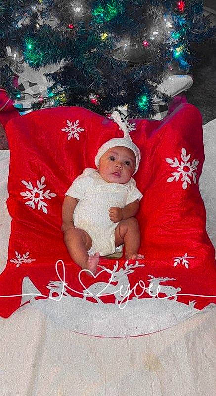 La'Quinta is registered to the contest to win money with this photo: baby, baby_toddler_clothing, carmine, child, christmas, christmas_decoration, christmas_eve, christmas_ornament, christmas_tree, event, fictional_character, fun, happy, headwear, holiday, human_body, interior_design, lap, person, santa_claus