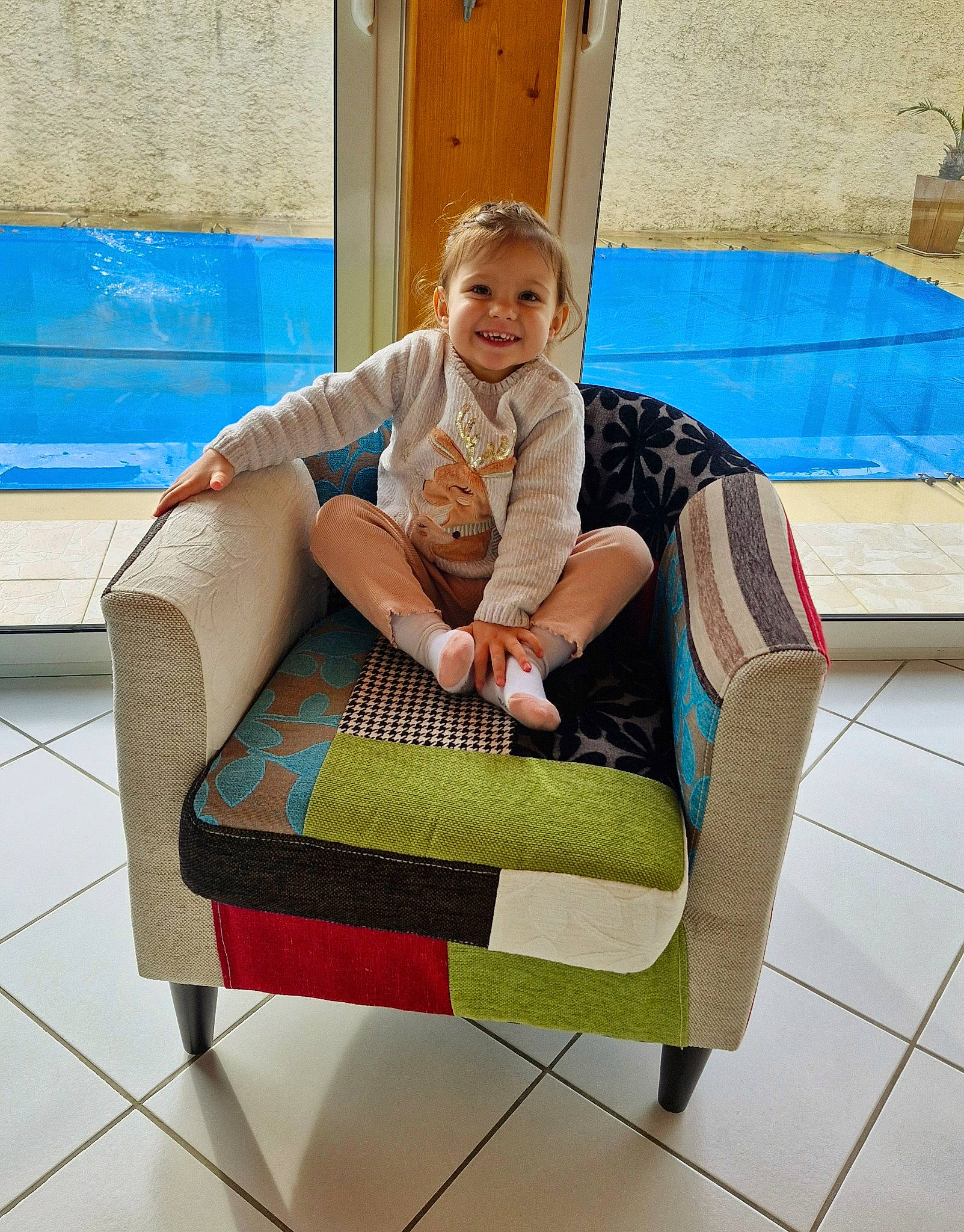 Léna a rejoint le concours — aidez-le/la à gagner de superbes lots ! baby_products, backpack, bag, blue, child, comfort, flooring, home_accessories, joy, leisure, luggage_and_bags, outdoor_furniture, pattern, person, play, recreation, room, shoe, sitting, smile