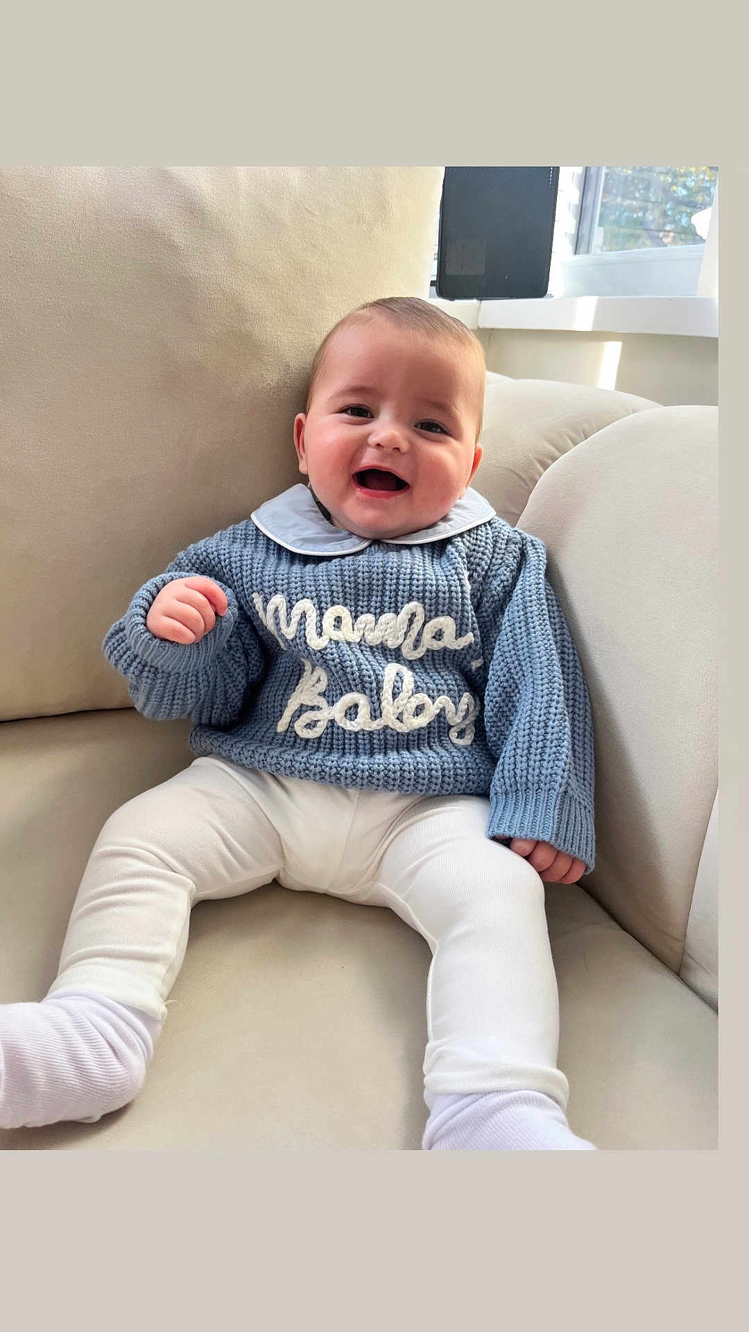 Jimmyjohn joined the competition — help win amazing prizes! baby, child, smiling, sweater, knitted, blue, white_pants, socks, couch, indoor, window, natural_light, happy, cute, portrait, seated, cozy, comfortable, face, person