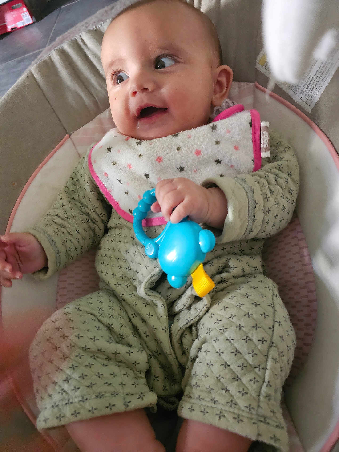 Inaya a rejoint le concours — aidez-le/la à gagner de superbes lots ! baby, infant, smile, toy, bib, onesie, cushion, seat, happy, child, hand, face, clothing, indoor, closeup, cute, looking, playful, comfort, expression