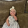 Leni-Rose is registered to the contest to win money with this photo: baby, child, girl, dress, headband, bow, couch, cushion, striped, window, indoor, person, smiling, cute, seated, hand, face, clothing, home, cozy