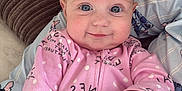 Leni-Rose is registered to the contest to win money with this photo: baby, child, infant, pink_onesie, polka_dots, smile, face, hand, couch, pillow, adult_hand, blue_cord, blanket, comfort, indoor, portrait, cute, happy, closeup, person