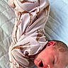baby, infant, sleeping, yawning, onesie, giraffe_pattern, clothing, quilted_bedspread, soft_texture, newborn, cute, peaceful, lying_down, pajamas, child, face, skin, head, mouth_open, resting