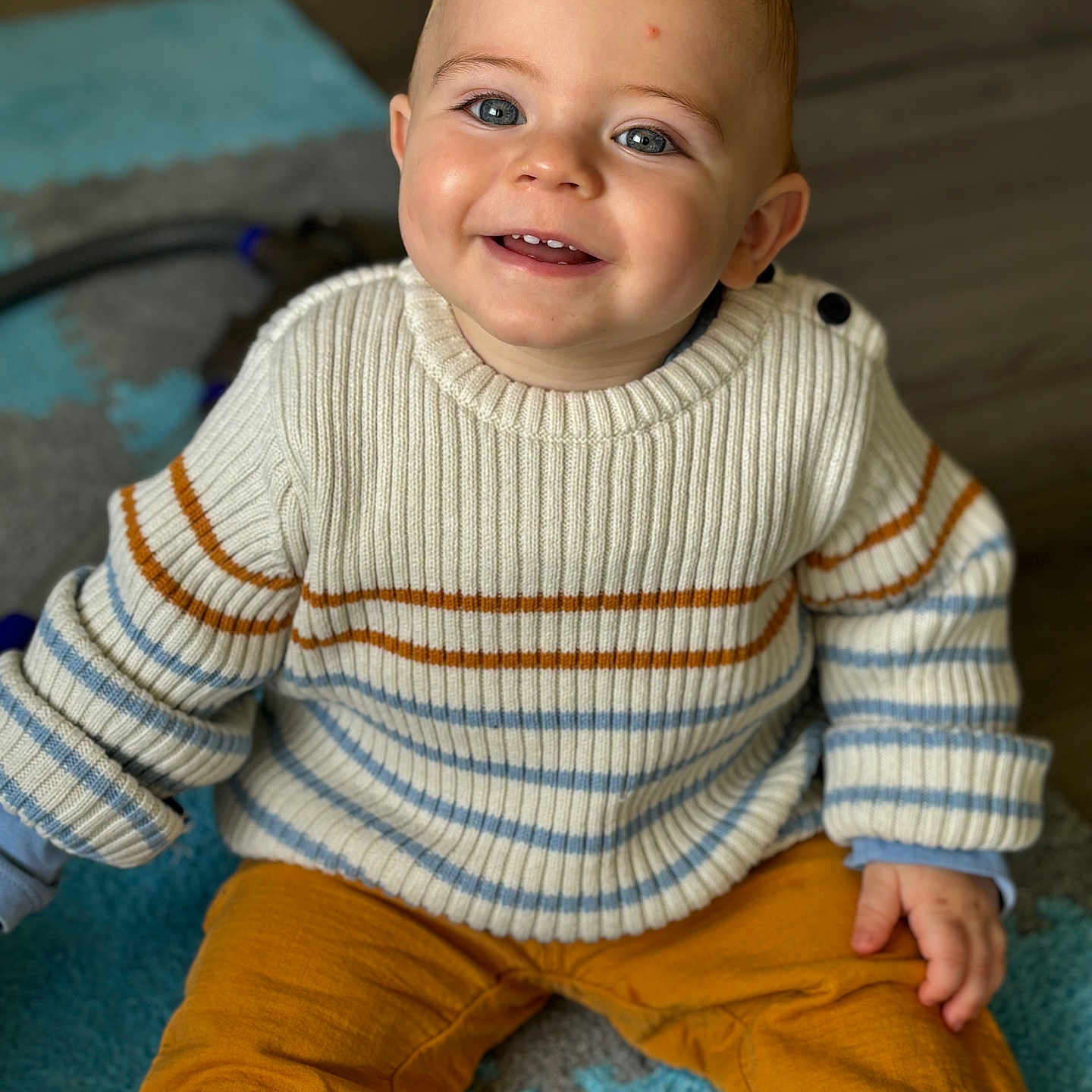Alessio participe au concours pour gagner de l'argent avec cette photo : baby, babylaughing, bodypart, clothing, face, finger, hand, happy, head, jeans, knitwear, longsleeve, pants, person, photography, portrait, sitting, sleeve, smile, sweater