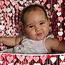 accessories, baby, clothing, crib, dress, face, furniture, happy, head, heart, infantbed, jewelry, necklace, newborn, person, photography, portrait, sitting, smile, symbol