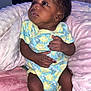 Jazaria is registered to the contest to win money with this photo: baby, infant, child, onesie, socks, blanket, pink, blue, yellow, floral_pattern, curly_hair, soft_texture, cushion, seated, looking_up, indoors, cozy, cute, small_hands, newborn