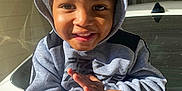 Jamarie Carr is registered to the contest to win money with this photo: child, smiling, hoodie, sweatshirt, pants, car, sunlight, outdoor, happy, face, person, clothing, vehicle, portrait, hands, casual, young, cute, hood, playful
