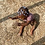 child, toddler, sand, playground, beads, hair, sitting, arms, legs, feet, shadow, outdoor, sunlight, texture, play, fun, clothing, skin, person, daytime