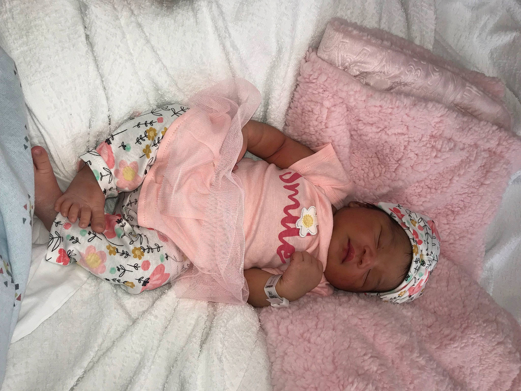 Zamiyah is registered to the contest to win money with this photo: abdomen, baby, baby_sleeping, baby_toddler_clothing, bedding, comfort, dress, finger, hand, headwear, human_body, linens, mammal, pattern, person, pink, room, skin, sunglasses, textile