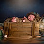 baby, newborn, wooden_crate, knitted_hat, knitted_outfit, fishing_rod, lantern, wooden_fish, bucket, reflection, water, cozy, rustic, portrait, cute, infant, props, studio, dark_background, smiling