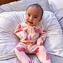 Zoey is registered to the contest to win money with this photo: baby, child, onesie, butterfly, pink_clothing, pillow, bed, infant, cute, smile, portrait, indoors, soft, comfortable, apparel, sitting, young_child, face, head, person