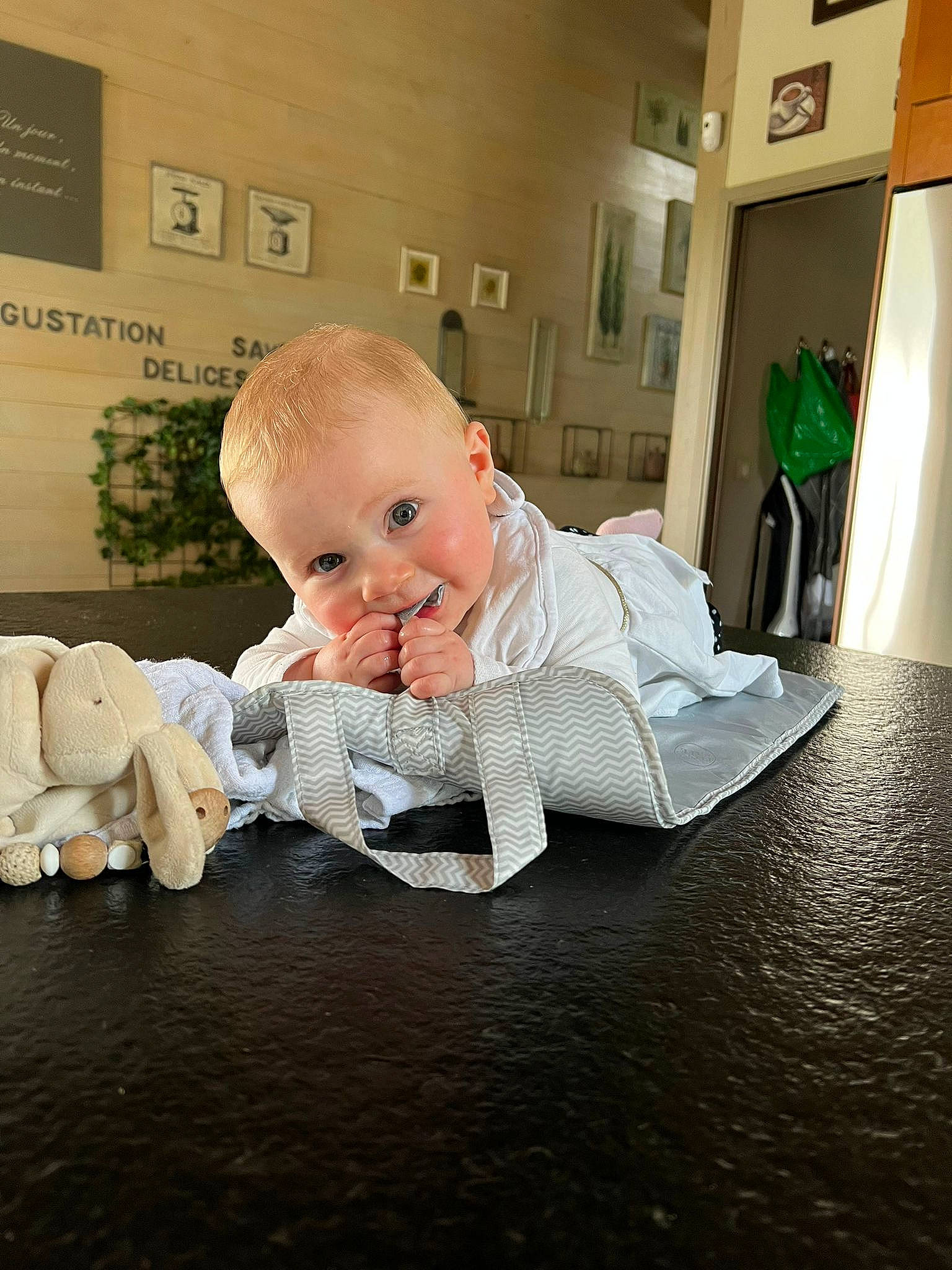 Emma a rejoint le concours — aidez-le/la à gagner de superbes lots ! baby, baby_products, baby_toddler_clothing, carpet, child, comfort, curtain, floor, flooring, fun, hardwood, houseplant, linens, mammal, person, picture_frame, room, sitting, toddler, wood