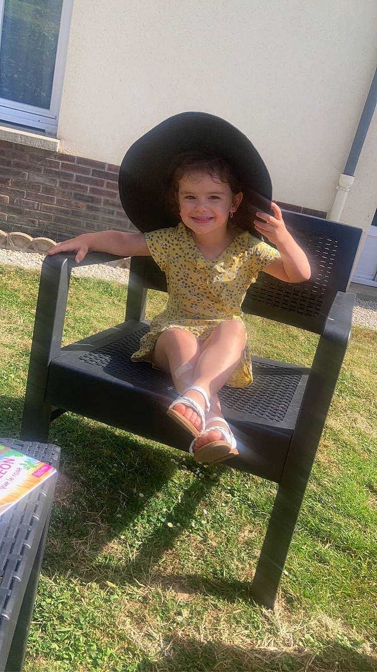 Madison participe au concours pour gagner de l'argent avec cette photo : barefoot, child, fashion_accessory, foot, fun, grass, hat, human_body, human_leg, joy, leg, leisure, outdoor_furniture, outdoor_table, person, recreation, sitting, smile, sun_hat, thigh