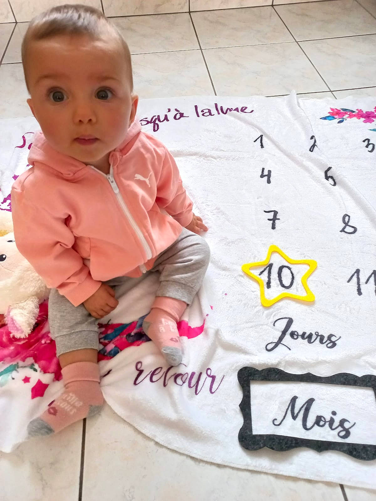 Inaya a rejoint le concours — aidez-le/la à gagner de superbes lots ! baby, baby_toddler_clothing, cheek, child, flooring, font, fun, handwriting, happy, magenta, number, pattern, person, play, sitting, sleeve, sock, surprise, t_shirt, toddler
