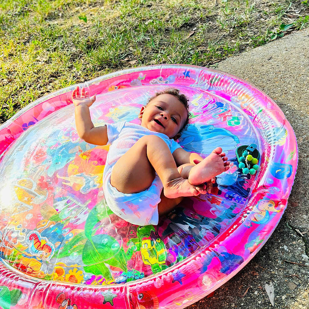 Zuri is registered to the contest to win money with this photo: baby, backyard, clothing, diaper, face, grass, head, nature, outdoorplayarea, outdoors, park, person, photography, plant, playarea, portrait, summer, swimwear, water, yard