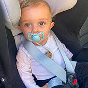 Soan a rejoint le concours — aidez-le/la à gagner de superbes lots ! baby, pacifier, car_seat, child, infant, seat_belt, safety, clothing, white_shirt, black_pants, close_up, cute, human, young_child, portrait, indoor, seat_harness, child_safety, person, baby_face