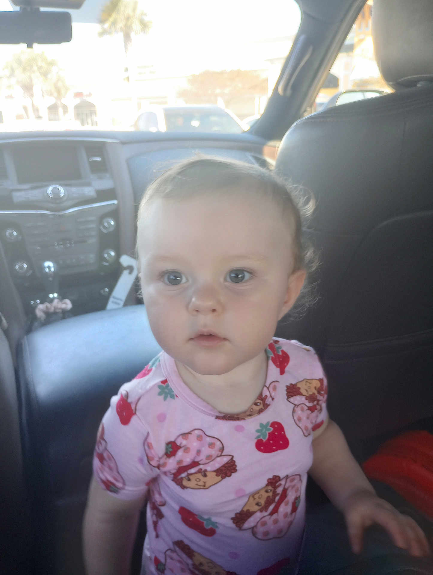 Sofia joined the competition — help win amazing prizes! toddler, child, car_interior, seat, leather_seat, dashboard, clothing, curly_hair, face, portrait, indoor, seatbelt, window, daylight, person, cute, expression, young_child, casual, pink_shirt
