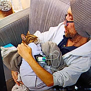 Saturn joined the competition — help win amazing prizes! animal, arm, beanie, blanket, casual_clothing, cat, comfort, couch, face, glasses, gray_hoodie, human, indoor, man, medical_equipment, pet_care, seated, tenderness, tubing, wrapped