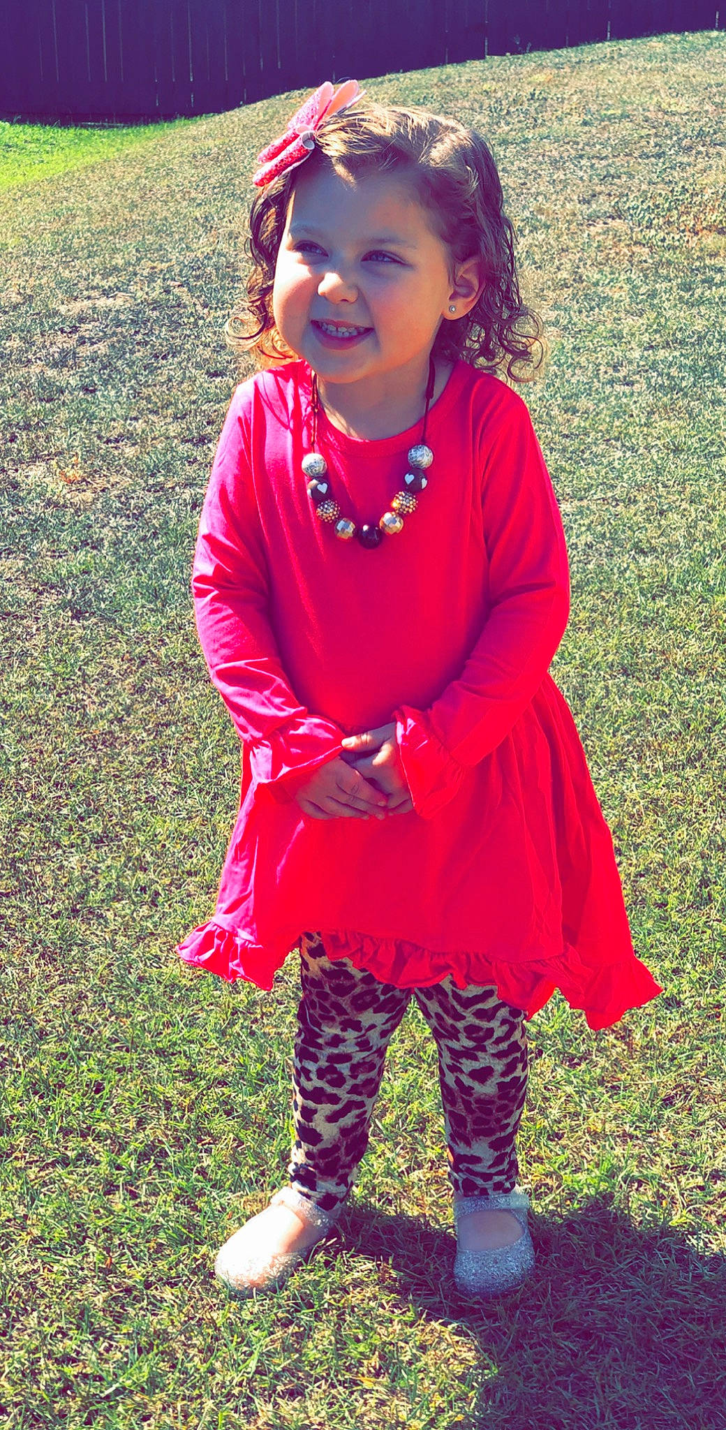 Amelia is registered to the contest to win money with this photo: child, child_model, clothing, dress, fashion_accessory, footwear, grass, joy, leggings, magenta, outerwear, pattern, person, pink, red, shoe, smile, style, tights, toddler