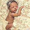 baby, sleeping, tiara, newborn, diaper, flower_pattern, blanket, soft_texture, cute, infant, portrait, peaceful, resting, child, adorable, skin, closeup, headwear, lying_down, cozy