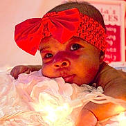 Keniya joined the competition — help win amazing prizes! adorable, baby, child, closeup, cute, decor, diaper, face, headband, holiday, indoors, infant, lights, lying_down, portrait, red_bow, skin, soft_texture, warm_lighting, white_blanket