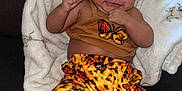 Armani joined the competition — help win amazing prizes! baby, child, smiling, bow, butterfly, pants, tank_top, blanket, couch, indoor, cute, happy, infant, cozy, fashion, person, portrait, feet, furniture, relaxing