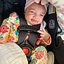 baby, infant, car_seat, child, smile, pacifier, blanket, headwrap, floral_pattern, onesie, safety_harness, pink, black, seatbelt, clothing, cute, indoors, portrait, person, baby_girl