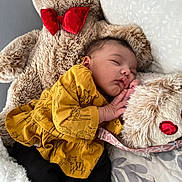 Analaxia is registered to the contest to win money with this photo: baby, sleeping, teddy_bear, stuffed_animal, yellow_clothing, red_bow, bed, blanket, pillow, animal_print, infant, child, cozy, cuddly, soft_toy, cute, peaceful, rest, indoors, portrait
