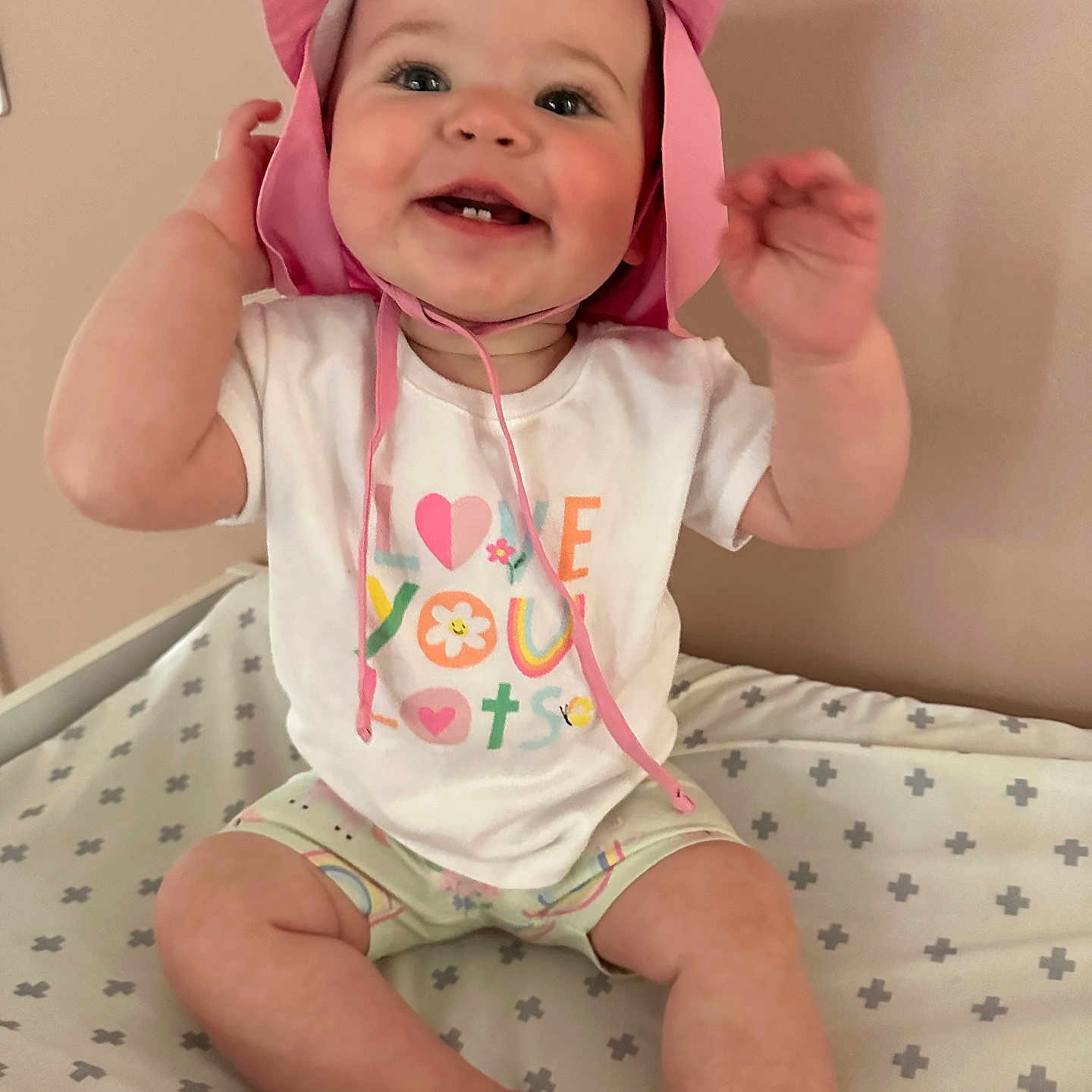 Chloe joined the competition — help win amazing prizes! baby, babylaughing, bed, bodypart, bonnet, clothing, cushion, diaper, face, finger, hand, happy, hat, head, homedecor, person, photography, portrait, sitting, smile