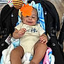 Romeo joined the competition — help win amazing prizes! baby, infant, car_seat, blanket, toy, hanging_toy, orange_teether, smiling, happy, indoor, floor, wooden_floor, clothing, onesie, person, child, cute, comfort, relaxed, playful