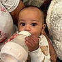 Romeo joined the competition — help win amazing prizes! baby, bottle, feeding, child, pajamas, bear_pattern, hand, face, eyes, person, arm, tattoo, blanket, couch, clothing, indoor, closeup, infant, holding, resting