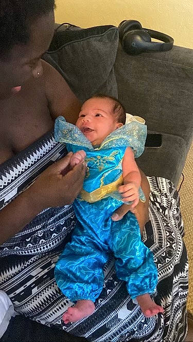 Zaneya is registered to the contest to win money with this photo: azure, baby, baby_toddler_clothing, child, comfort, couch, event, fun, gesture, hairstyle, happy, human, jewellery, lap, person, purple, sitting, t_shirt, textile, toddler