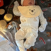 Lincoln is registered to the contest to win money with this photo: baby, infant, onesie, bib, hat, blue_socks, soft_toys, crib, blanket, candy_cane, gingerbread_man, sleepwear, face, person, lying_down, indoors, cute, festive, comfort, child